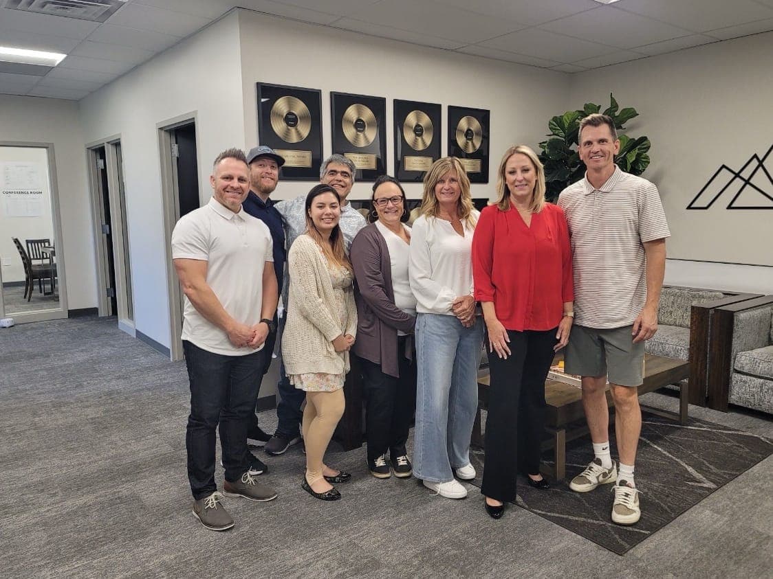 Eight Property Seller Solutions team members standing together in an office
